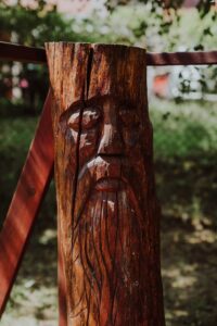 Zdjęcie przedstawia twarz wyrytą w drewnie