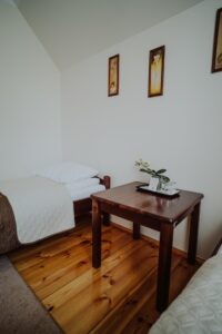 Zdjęcie przedstawia pokój noclegowy z łóżkiem i stolikiem