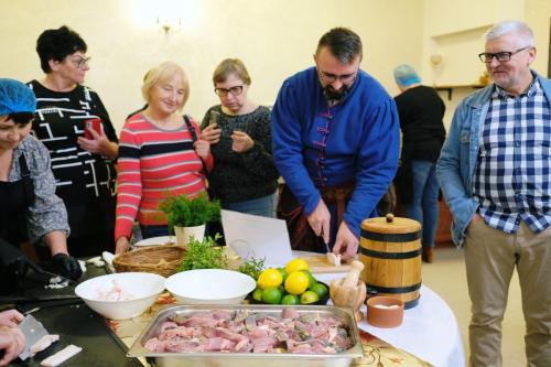Zdjęcie przedstawia ludzi przygotowujących posiłek